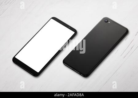 Two phones on desk. Front and back side positioned on a white wooden table. Isolated screen for mockup, app or web site presentation. Close-up, isomet Stock Photo