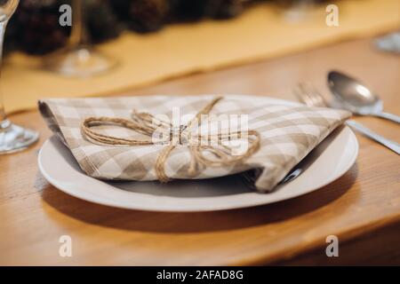Plate served with checked napkin on dining table. Stock Photo