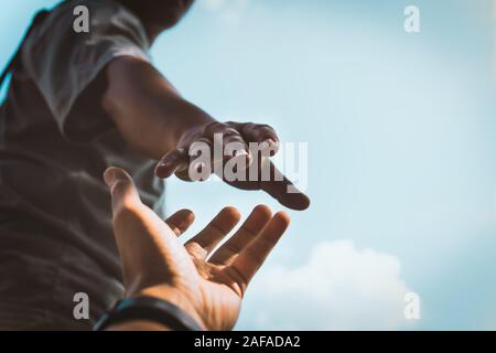 Help Concept hands reaching out to help each other in dark tone. Stock Photo