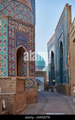 Shirin Biqa Aqa or Octagonal Mausoleum and narrow path through facades heavily decorated with blue tiles in necropolis Shah-i-Zinda, Samarqand, Uzbeki