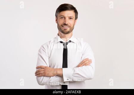 Positive Business Guy Smiling Crossing Hands Standing In Studio Stock Photo