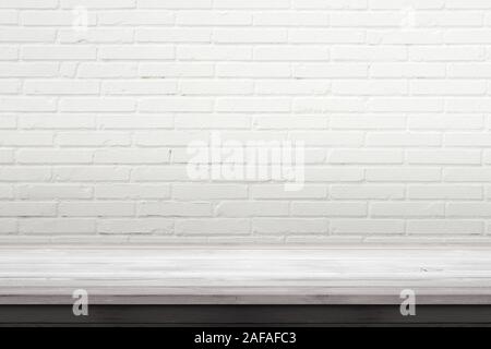 Empty wooden desk with white brick wall in background. Space for product promotion Stock Photo