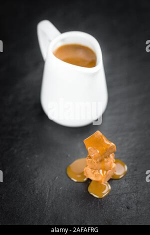 Caramel Sauce on a vintage slate slab (close-up shot; selective focus) Stock Photo