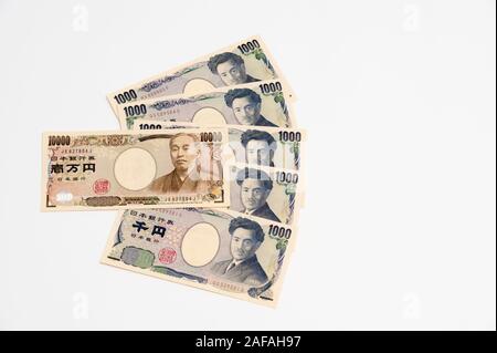 Yen - Japanese money in one thousand yen and ten thousand yen banknotes isolated on white background with copy space. Horizontal shot. Stock Photo