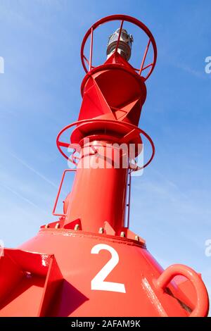 red lateral buoy against blue sky Stock Photo