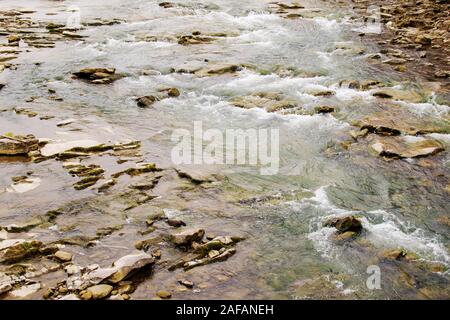 River water flowing through stones and rocks. Stock Photo