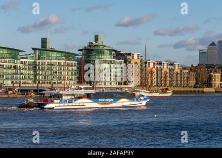 Historic vessels moored at the Hermitage Community Moorings with modern development apartments, Wapping, London, UK. Thames Clippers riverbus boat Stock Photo