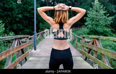 Unrecognizable sportswoman doing stretching arms outdoors Stock Photo