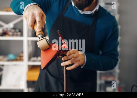 Shoemaker repairing shoe, footwear repair service Stock Photo