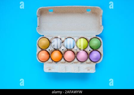 Various color eggs in box of ten, ready for Easter on blue background Stock Photo