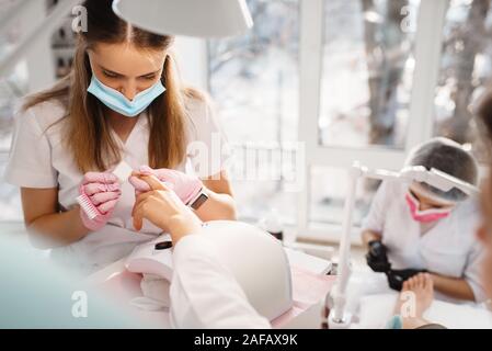 Two masters, pedicure and manicure procedure Stock Photo