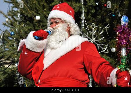 Cherkasy, Ukraine,December,30, 2012:   Santa Claus speak near the  fir-tree with  christmas decorations Stock Photo