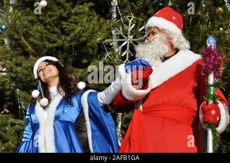 Cherkasy, Ukraine,December,30, 2012: Santa Claus with a snow maiden took part in New year show near the Christmas tree Stock Photo