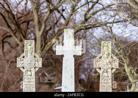 Three stone crosses, tow ornate and one plain in  winter landscape Stock Photo