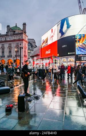 Guitar playing, musician, busker, busking, Picadilly Circus, London, England, UK Stock Photo