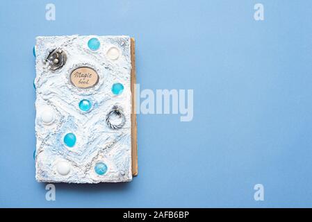White magic book on blue background with copy space top view. Stock Photo