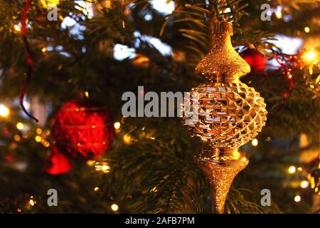 Gold Christmas ornament on a decorated Christmas tree Stock Photo