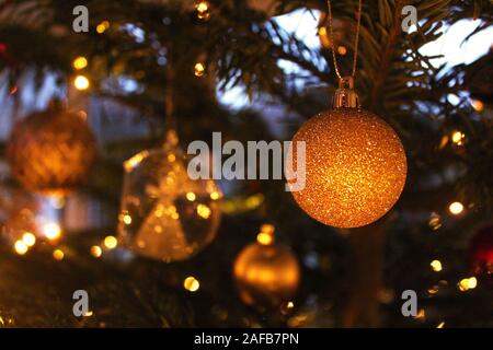 Gold shimmery Christmas ornament on a decorated Christmas tree Stock Photo