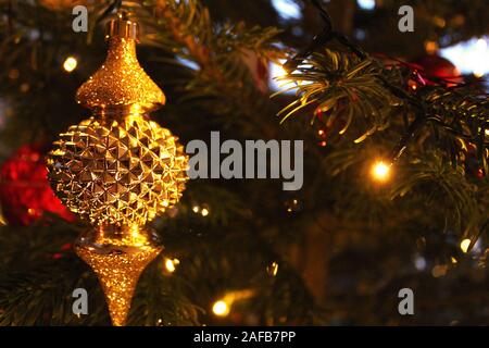 Gold Christmas ornament on a decorated Christmas tree Stock Photo