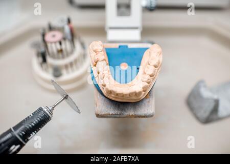 Artificial jaw for implants modeling with set of dental burs at the working place of dental technician in the laboratory Stock Photo