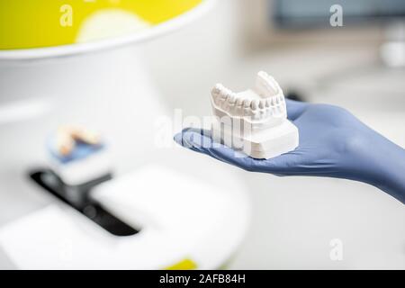 Holding a gypsum model of artificial jaw on the 3d scanner at the dental laboratory Stock Photo