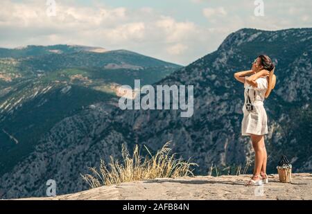 Young woman in fashion dress, standing in front of Delfi mountain landscape  in Delphi, Greece Stock Photo - Alamy