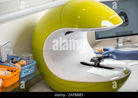 Dental technician placing jaw model into the 3d scanner at the laboratory Stock Photo