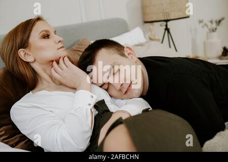 Business couple on bed in hotel room - tender hugs Stock Photo
