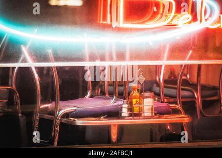 Looking through the window of a closed diner or deli with the chairs turned up on the tables Stock Photo