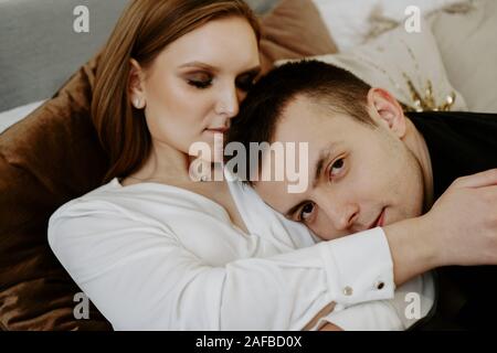 Business couple on bed in hotel room - tender hugs Stock Photo