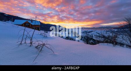 mountainous countryside in winter at dawn. snow covered hills and fields of carpathian rural area rolling off in to the distant krasna ridge. glowing