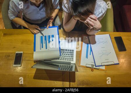 High angle view of two businesswomen working on chart document Stock Photo