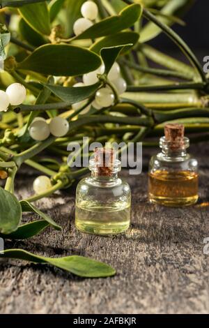 A bottle of essential oil with fresh mistletoe twigs Stock Photo