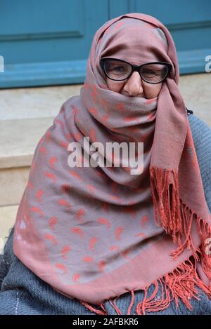 Elderly lady, shrouded in a blanket, veiling her face with a scarf, Essaouira, Morocco, North Africa. Stock Photo