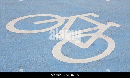 Bicycle lane road marking on blue painted asphalt. Stock Photo