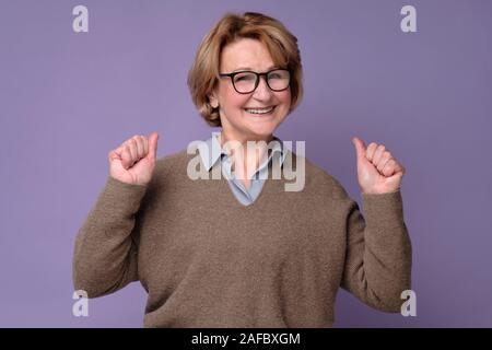 Senior woman in glasses is surprised with great news. Studio shot Stock Photo