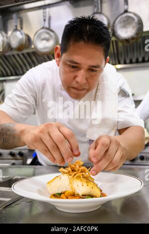 Iguana Restaurant chef putting finishing touch on Chilean Sea Bass entree at Casa Kimberly, Puerto Vallarta, Jalisco, Mexico. Stock Photo