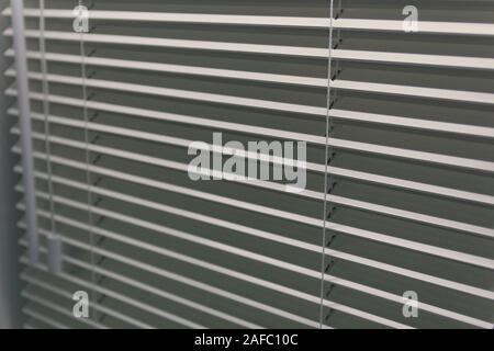 White horizontal blinds on the window close-up. Interior Stock Photo