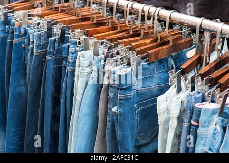 jeans on hangers, second hand clothing - Stock Photo