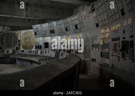 The control room of Chernobyl’s reactor four, the site of the world’s most devastating nuclear catastrophe. The former nuclear power plant’s control room is where engineers shut down the reactor’s cooling pumps as part of a safety test in April 1986, which led to an explosion that killed at least 28 people in the immediate aftermath and contaminated the surrounding area. The room, located under a 36,000-tonne steel containment arch, still has its original display screens and panels of command buttons. Chernobyl, Ivankiv Raion, Kiev Oblast, Ukraine, Europe Stock Photo