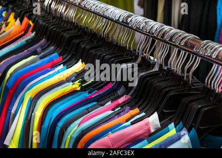 colorful t-shirts hanging on second hand clothing market Stock Photo