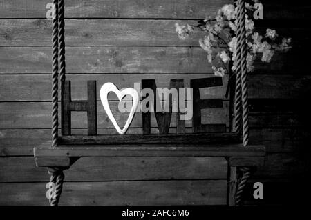 Decorative letters forming word HOME with heart on wooden