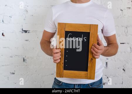Board with new goals. Enter new goals. The inscription in chalk on a black chalkboard in a frame of wood. Stock Photo