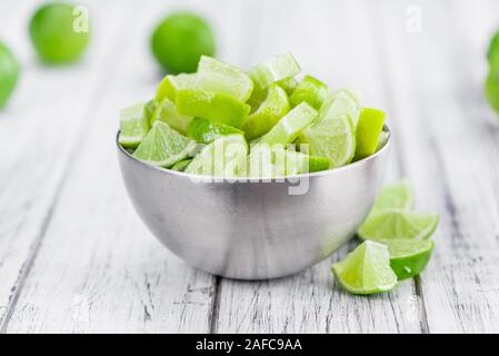 Sliced Limes on an old wooden table as detailed close-up shot (selective focus) Stock Photo