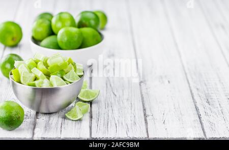Sliced Limes on an old wooden table as detailed close-up shot (selective focus) Stock Photo