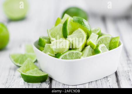 Sliced Limes on an old wooden table as detailed close-up shot (selective focus) Stock Photo