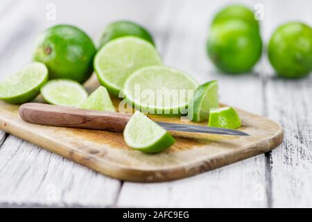 Sliced Limes on an old wooden table as detailed close-up shot (selective focus) Stock Photo