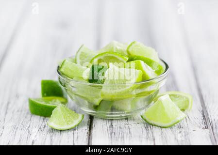 Sliced Limes on an old wooden table as detailed close-up shot (selective focus) Stock Photo