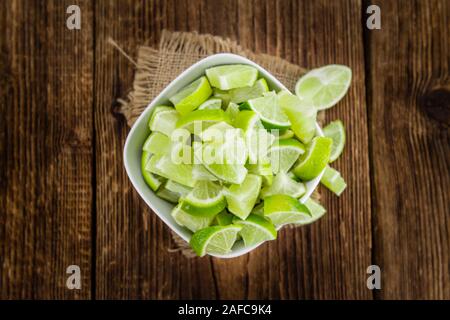 Sliced Limes on an old wooden table as detailed close-up shot (selective focus) Stock Photo