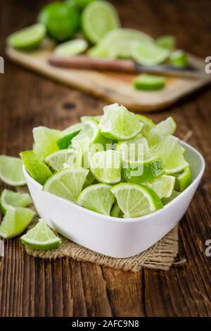 Sliced Limes on an old wooden table as detailed close-up shot (selective focus) Stock Photo
